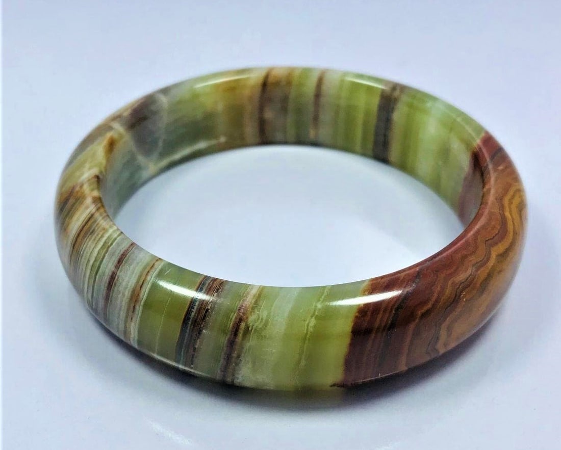 Onyx Beautiful hand bangle mix color 70.5G: Onyx Beautiful hand bangle greenish and redish mix color - 78.5mm - 70.5G Shipping: $23.00. Shipping rates are determined by Parcel weight and destination.