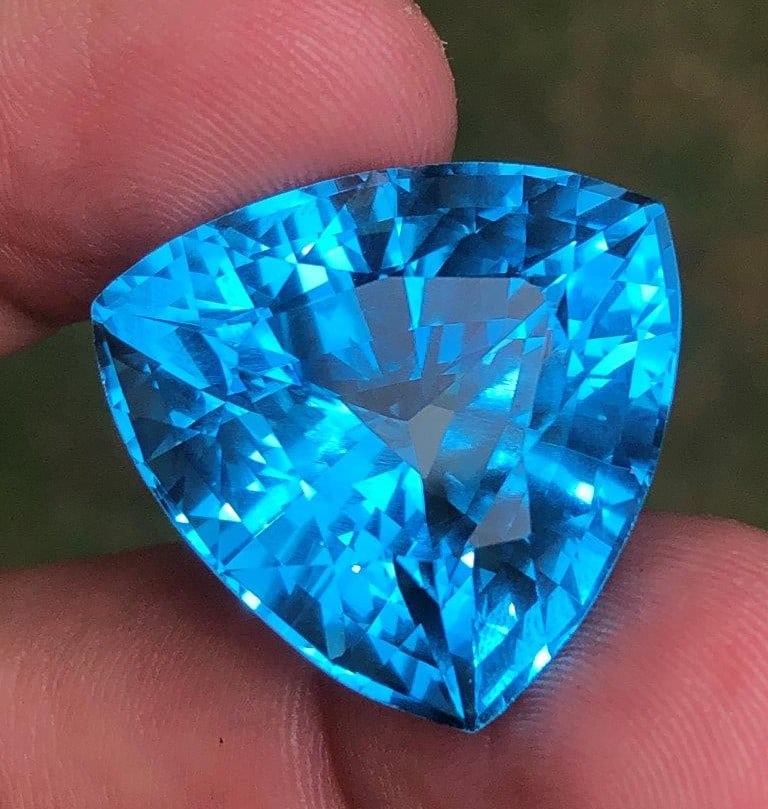 54.94 Carats AAA Swiss Blue Topaz – Flawless Quality Loose Gemstone (19×18×15 mm): This exceptional 54.94 carat Swiss Blue Topaz showcases a vivid, radiant blue color with AAA-quality clarity and a flawless finish. Measuring 19 × 18 × 15 mm, this large gemstone is expertly