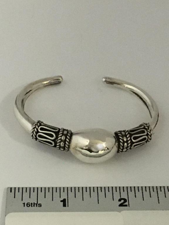Sterling Cuff Bracelet: 2 decorative shoulder bands 8.5 mm with center 15.6 mm elongated bead normal wear and scratches, 19.8 gms