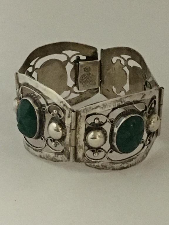 Sterling Scarob Bracelet: 4 sectional mask panel with 4 green scarob faces that measure 14 X 18 mm, , stamped Hecho En Mexico TN 211, 1 1/2" w x 7" long normal wear and scratches, 35.3 gms