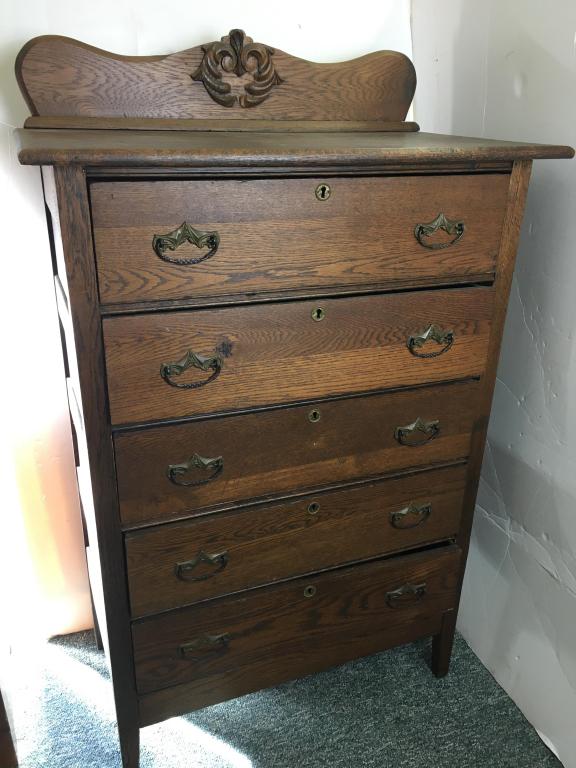 Oak Bureau w batwing brasses: 5 drawers, dovetailed drawers, paneled sides, applied crest on back splashboard, 33" x 18 3/4" x 54" h crack on applied crest, scratches and split on top
