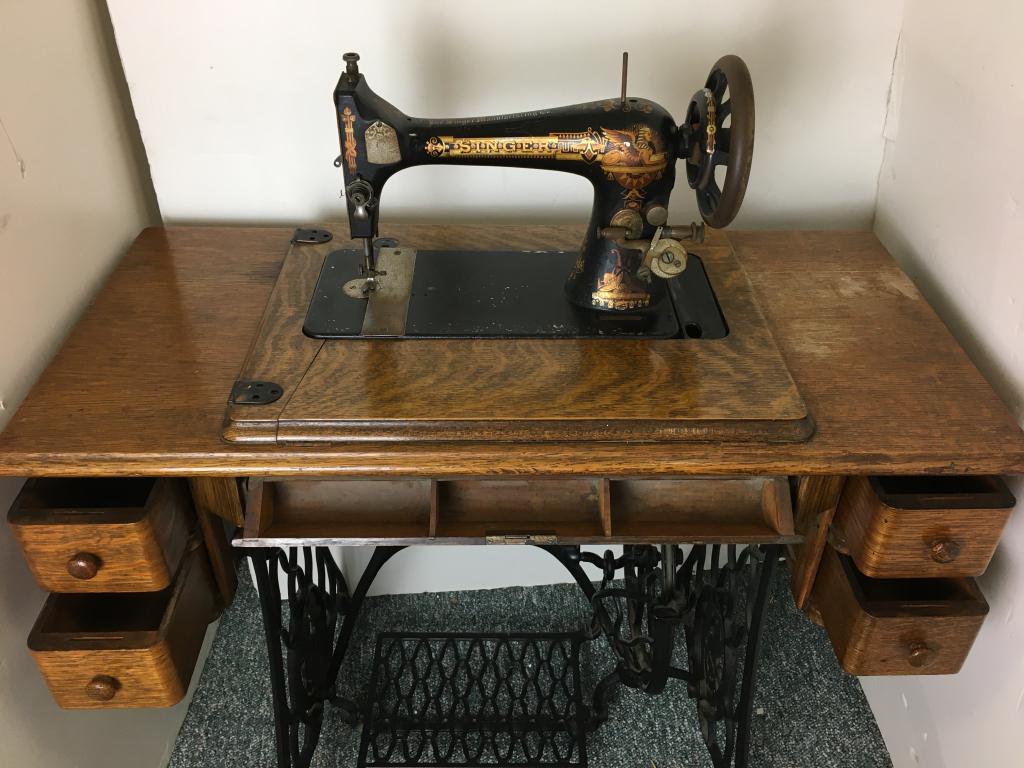 Oak Singer Sewing Machine: iorn base on casters, pedal base, 2 side drawers, 3 sectional storage, patd 1880s, pedal works, serial # 14028466, 35 1/2" x 17" x 31" h bobbin plate rusted, hinges broken, black plate worn, veneer da
