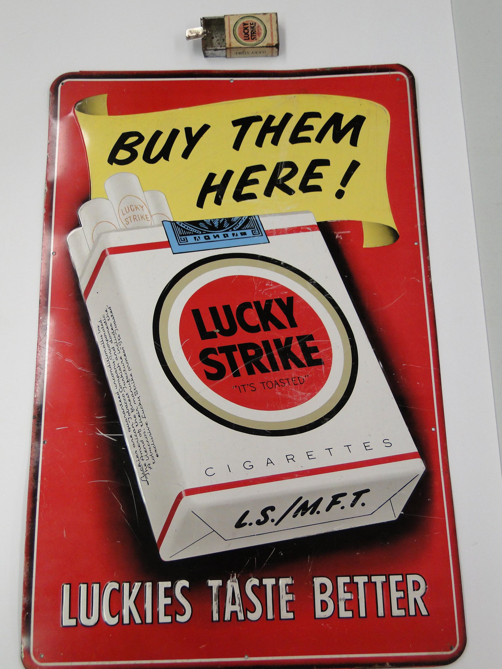 Vintage Lucky Strike Sign & ashtray: Lucky Strike pop out ashtray box, poor condition measures 2 1/4" x 1 3/4" x 1/2" and Metal Lucky Strike Advertising wall sign, 10 holes for hanging
