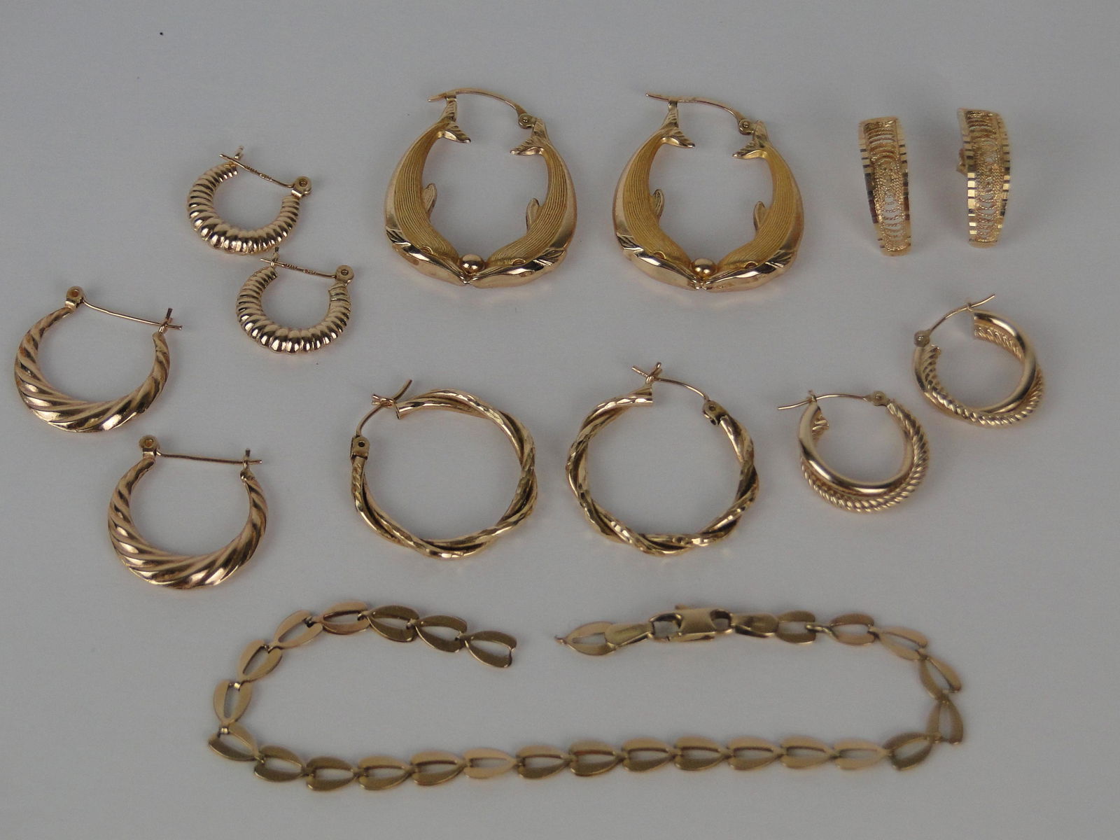 Lot of 14K Gold Earrings: and one 14K gold heart link 7" bracelet weighs 3.3 g and 6 pairs of 14K pierced earrings weigh 11 g