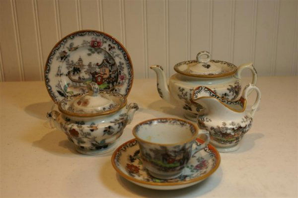 19th C English Child's Tea Set: 19th C English Child's Tea Set, Ironstone, "Opaque China" & crest mark, pattern # 1365, multi colored Oriental transfer design, consisting of Tea Pot (spout chip), cream, sugar, 6 cups (1 w/ rim chip