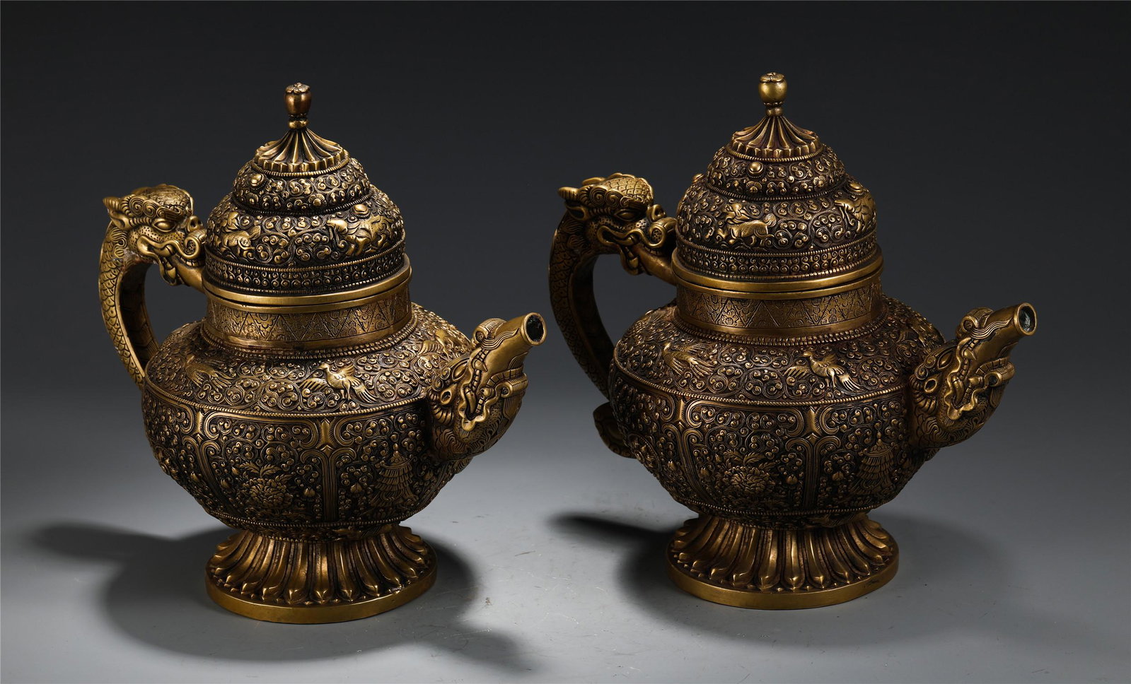 A PAIR OF CHINESE GILT BRONZE EIGHT TREASURES KETTLES: H. 28.5 cm. L. 30 cm. W. 17 cm. Each Weight 3010 gram.