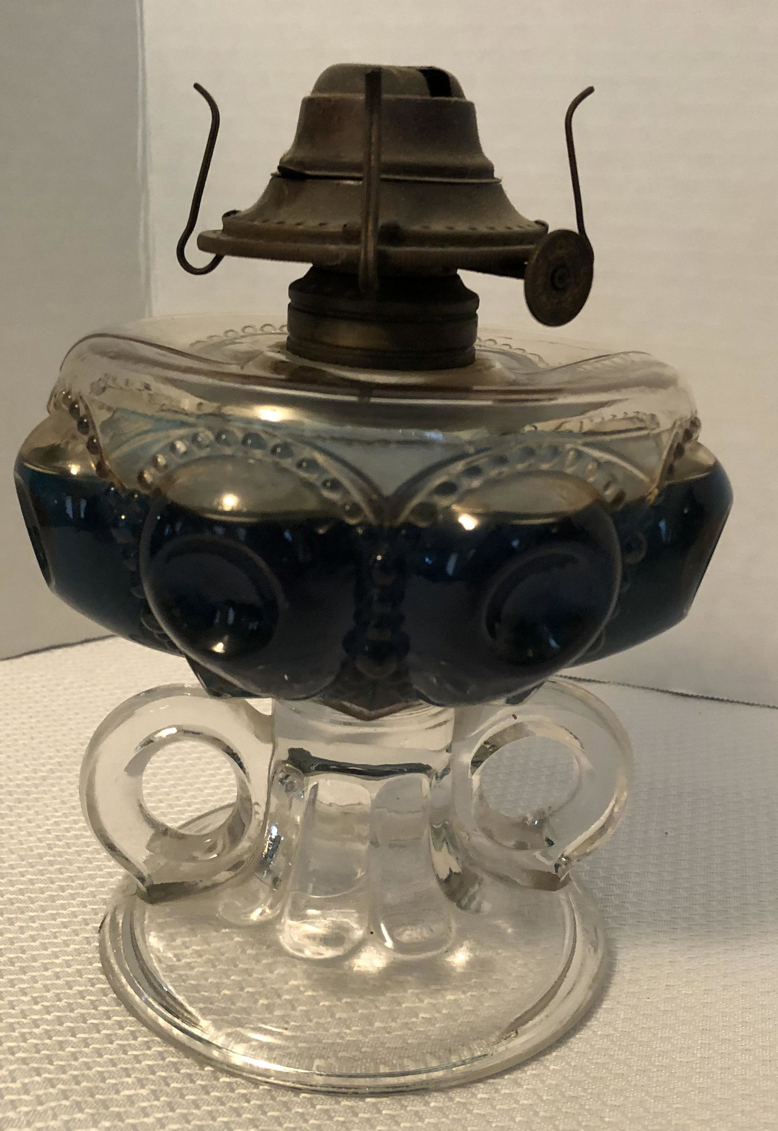 Antique Double handle Glass Kerosine Finger Lamp: Pictured with lamp oil that will be emptied.