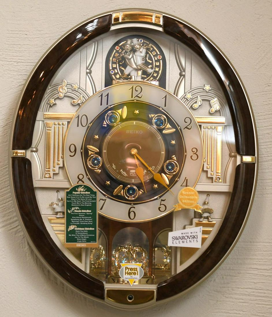 Swarovski Seiko Melodies in Motion Wall Clock: Requires 4 C batteries and 1 AA battery, has volume selector and can choose between 3 melodies, 2 springs in battery compartment are beginning to rust from leaving batteries in clock, 18-1/2" long x 1