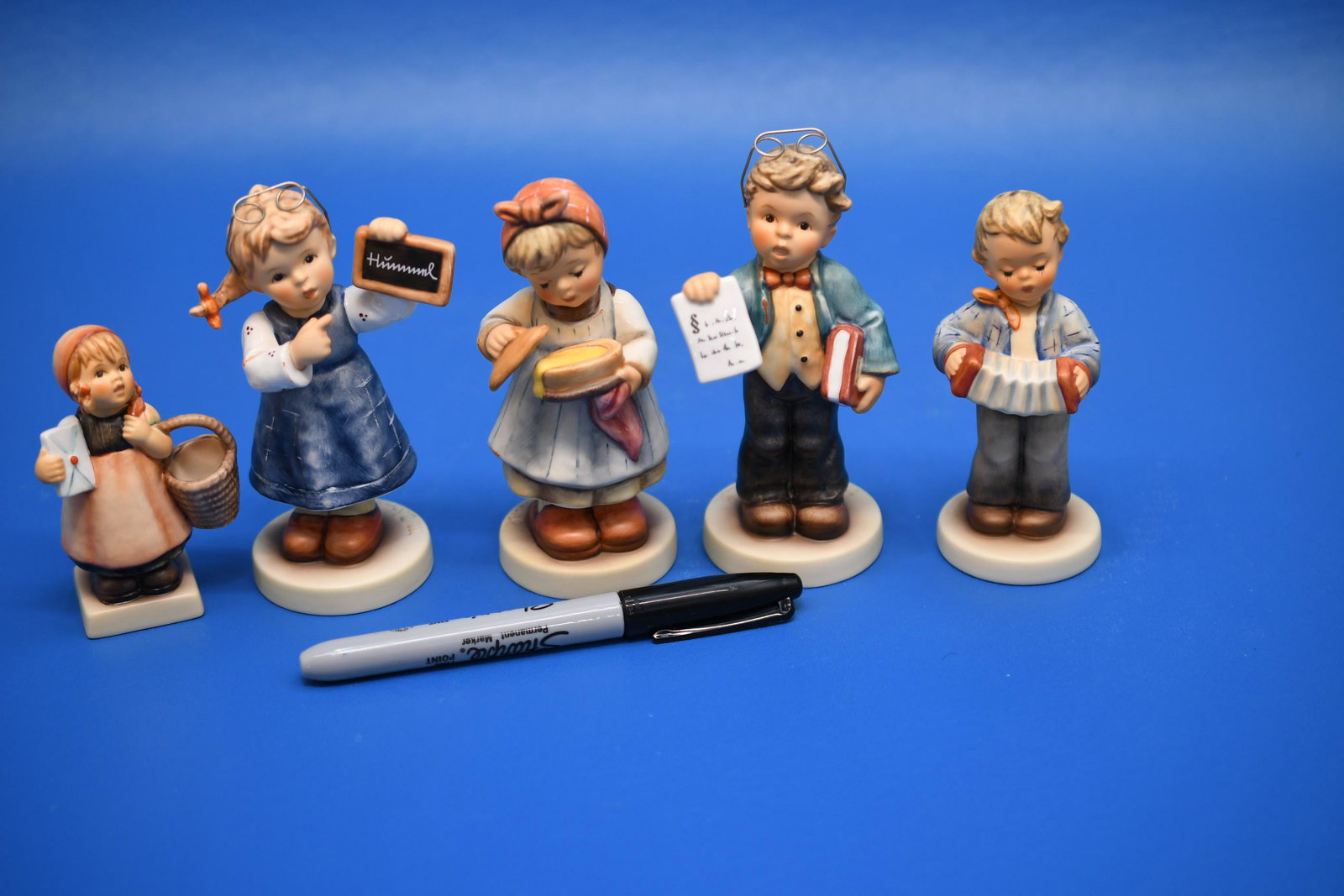 Hummels "5 First Issues": Left to right, the first is a 3-1/4" No 13 4/0 "Meditation", 2nd is 4-3/4" Original Hummel Teaching Time", 3rd is 4-3/4" Original Hummel "Bon Apetit", 4th is 4-3/4" Original Hummel "Little Lawyer", 5t