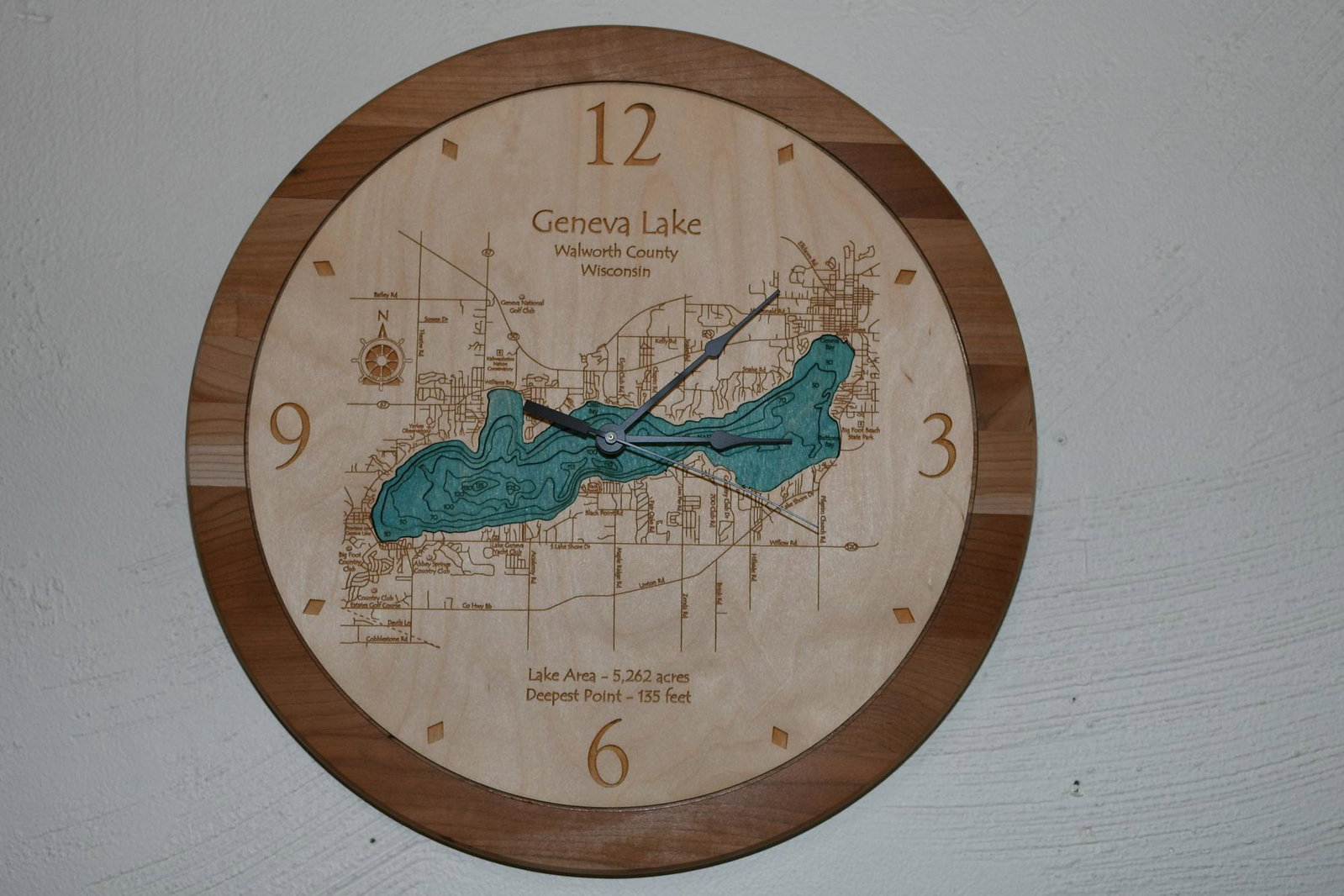 Lake Geneva Clock: This wonderful clock is made from cherry with a soft maple dial face & Geneva Lake, numbers and letters are all laser cut into layers of depth. It has a quartz clock. It is 17-1/2" dia x 3/4" thick, w