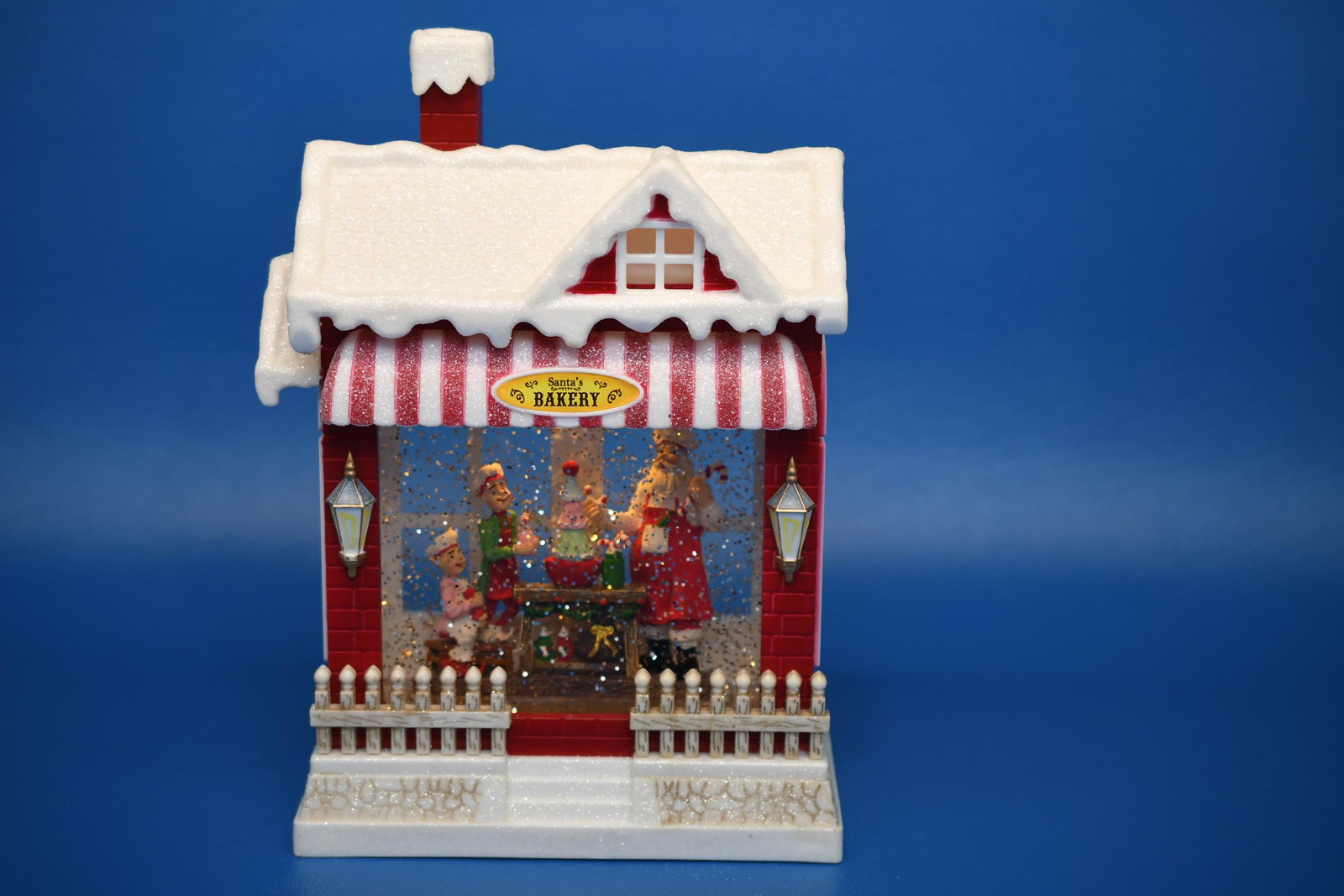 Santa's Bakery Animated Music Box: RAZ Imports Inc. Requires 3 AA batteries, Lights up and plays music, windows on all 4 sides, 10-1/2" tall x 7" wide x 3-5/8" deep, approximate weight 4lb 7oz