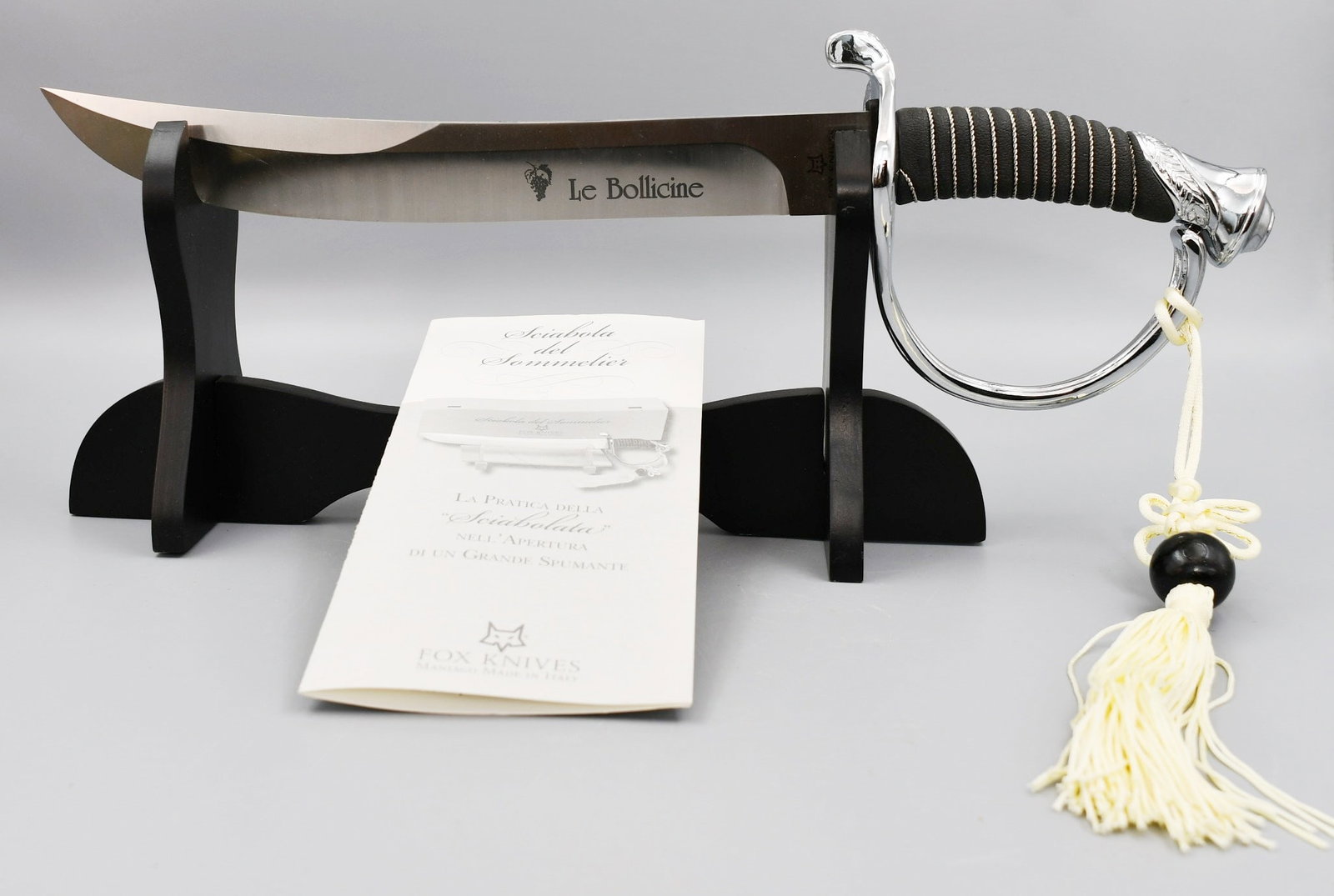 Sommelier's Saber: Fox Knives, Made in Italy. A Somelier's Saber for the practice of the "Opening" of great Sparkling Wine. Brand new, never used. Has a wood display stand. (NOTE-Weight and dimensions are before packagi