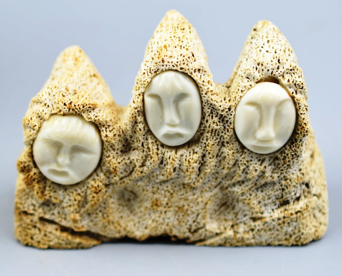 Inuit Art: Inuit beached Whale Bone carving with carved bone faces. (NOTE-Weight and dimensions are before packaging) Dimensions-3 5/8"x 2 1/2"x 1 5/8". Weight- 4.6oz.