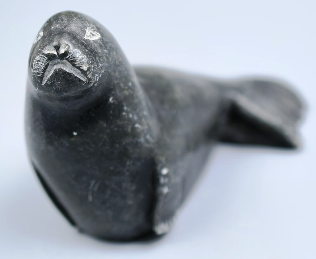 Inuit Sculpture: Inuit sculpture of a seal carved from soapstone signed on bottom Dimensions- 2 1/2"H. 3 1/4"L. 1 1/4"W. Weight- 7.1oz. (NOTE-Weight and dimensions are before packaging)