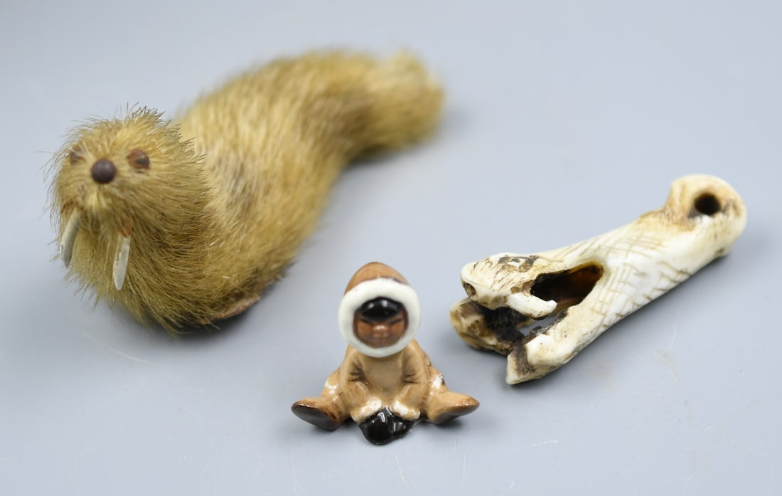Inuit Group: 3 pieces. Handmade seal from real animal hide, tusks are real bone. Snake head carved out of bone, possibly for a necklace. Tiny Inuit ceramic figure. (NOTE-Weight and dimensions are before packaging)