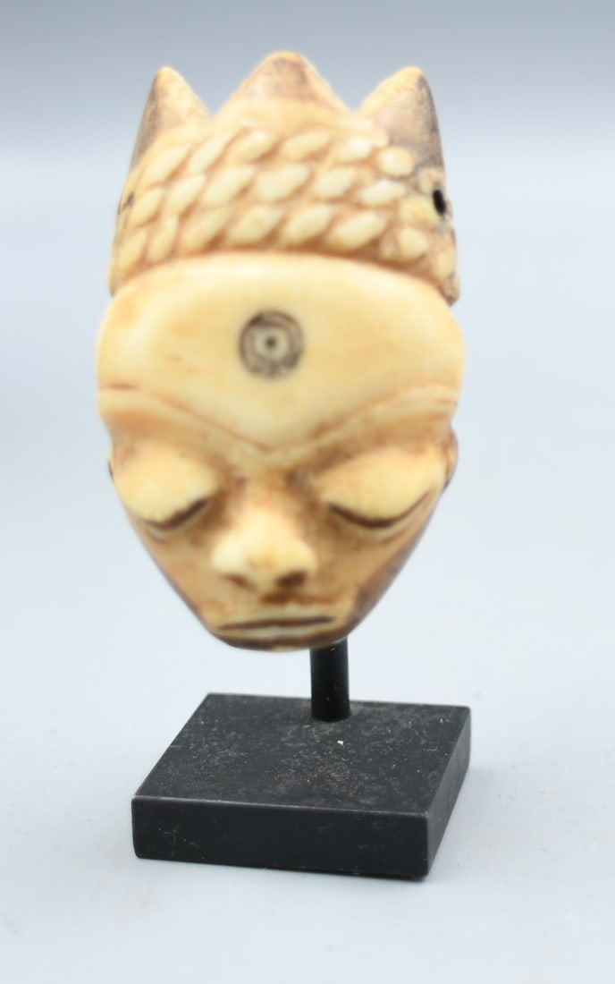 Antique African Bone Mask Pendant: African mask pendant carved from bone. (NOTE-Weight and dimensions are before packaging) pendant-2 1/4"L x 1 3/8"W. Weight-.85oz. Stand-1"x1"x2 1/4"T. Total Height-3". Combined weight- 2.20oz.
