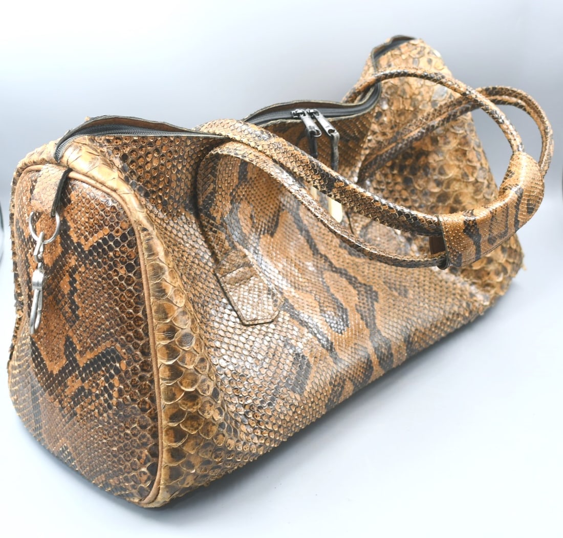 Medium Snake Skin Luggage: Medium size snake skin and leather luggage bag has a double strap, and a strap wrap with snaps plus 5 bone feet, maker unknown. (NOTE-Weight and dimensions are before packaging) dimensions-9"W x 20 1/