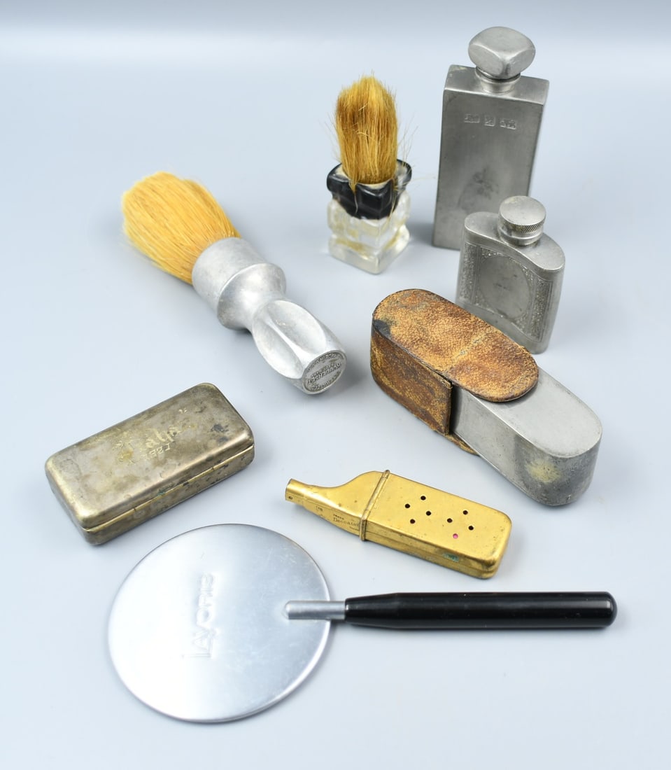 Shaving Supply Lot: 7 pieces; 2 foam brushes, 2 pewter aftershave flasks, 1 breakdown toothbrush, 1 container in leather pouch, 1 silver plated over brass container with the name "Praba, 1920" on it. (NOTE-Weight and dim