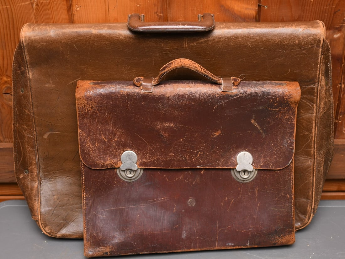 2 Leather Bags: 1 leather garment bag and 1 leather attach?. The attach? has two latches and locks. The garment bag has hangers inside and outside with a latch and lock. All zippers working properly. (NOTE-Weight and