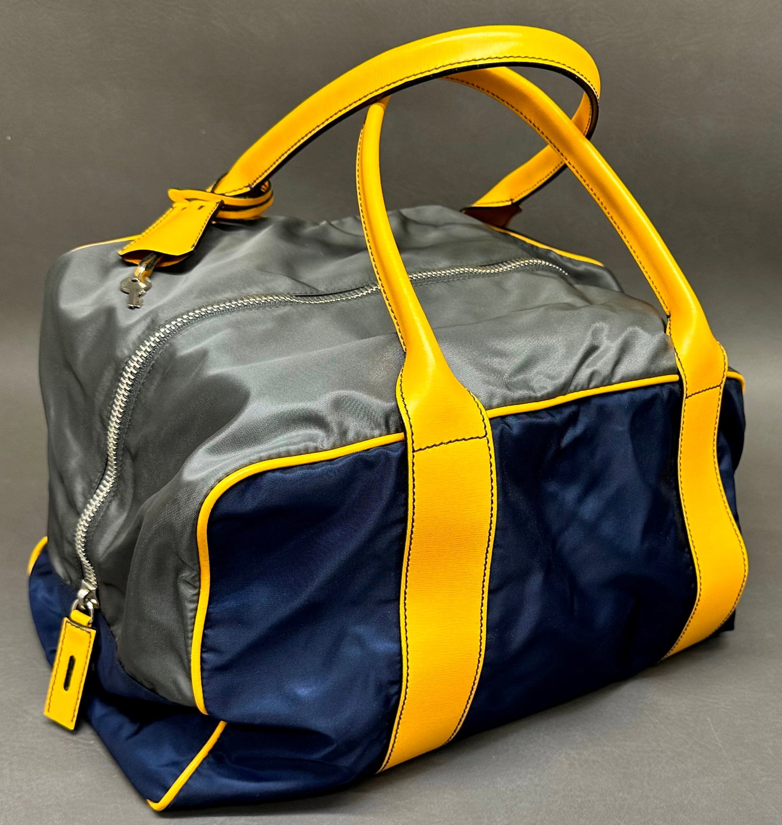 Prada Nylon Vela Duffle / Travel Bag: Navy blue with yellow leather accents. This bag includes the original keys in a leather pouch & lock as seen in the photos. Dimensions given are for the item(s) & weight is with the packaging.