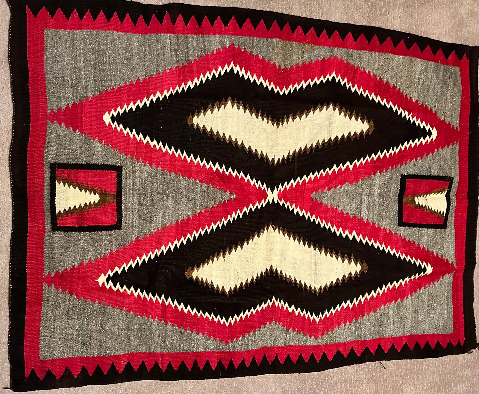 Navajo Rug: We are told this is a butterfly pattern from the early 1930's, It has a metal tag from Fred Harvey House as seen in the photos actual size is 47 x 67-1/2. Dimensions given are for the rug folded for s