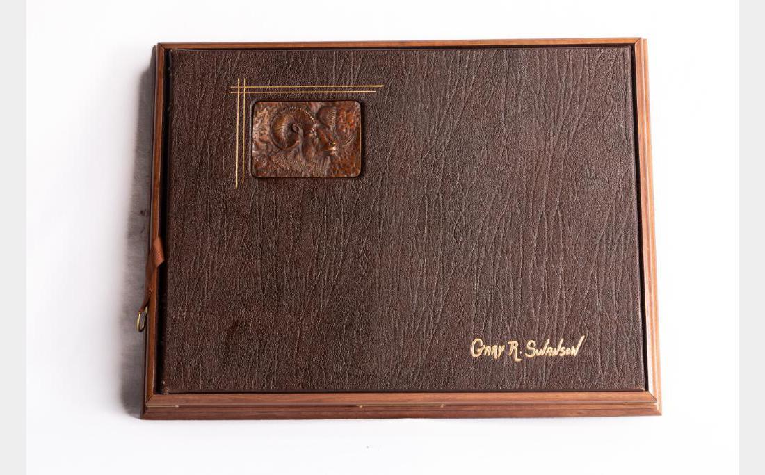 Gary Swanson, book: Gary Swanson (1941-2010) Special Edition Leather Bound Book with Big Horn Sheep bronze medallion on front. Book is 13.5" x 18.5", medallion is 3" x 4.25". $400-600
