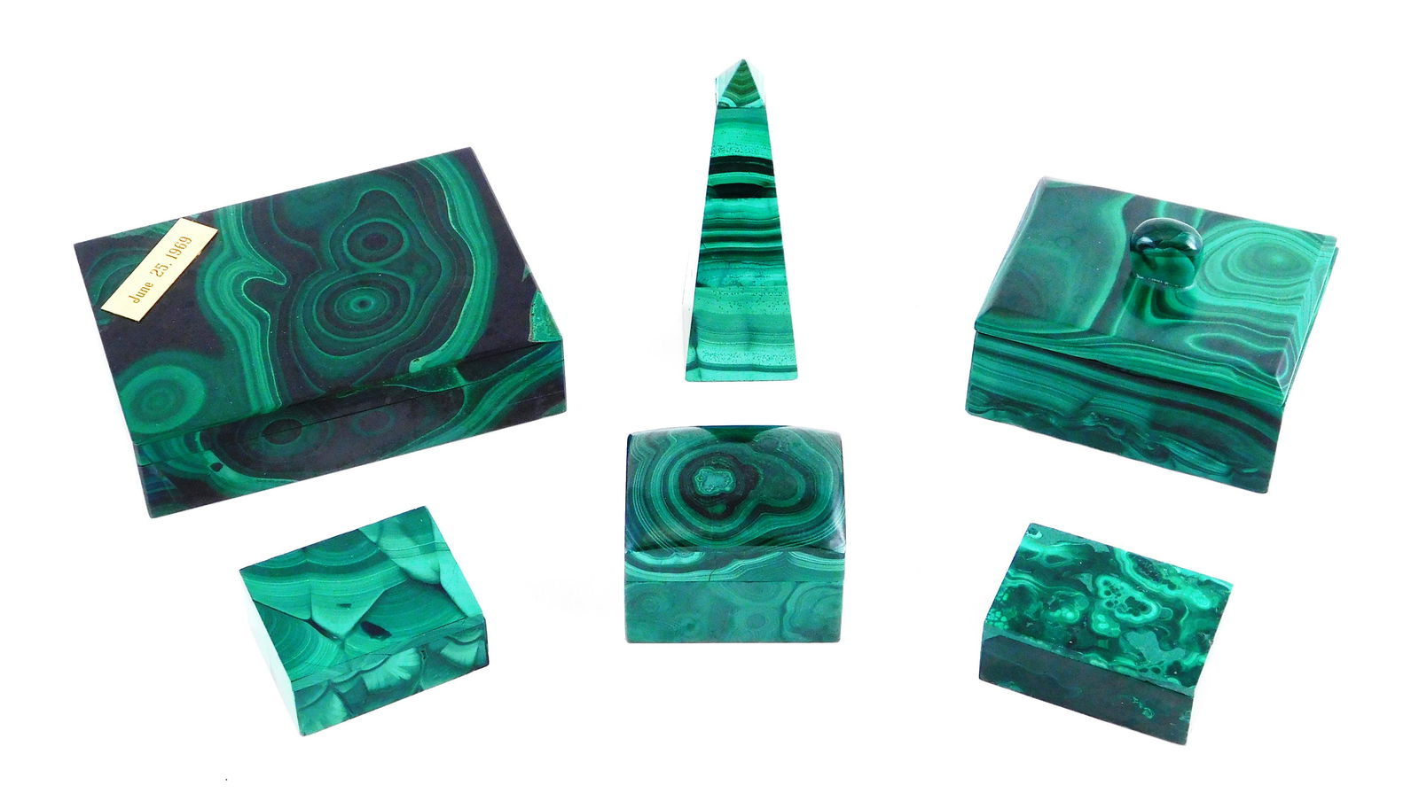Six malachite desk pieces, 20th C., including: five: Six malachite desk pieces, 20th C., including: five veneered boxes, 20th C., 2 /4" l. - 5 ¼" l., the largest with a brass plaque on the lid dated, "June 25, 1969"; along with a malachite veneered obe