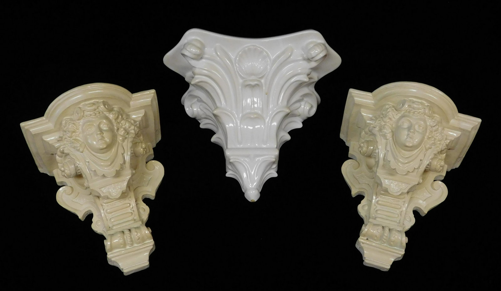 Three wall brackets, two ceramic in the form of: Three wall brackets, two ceramic in the form of Aesthetic portraits and one Corinthian capital.
