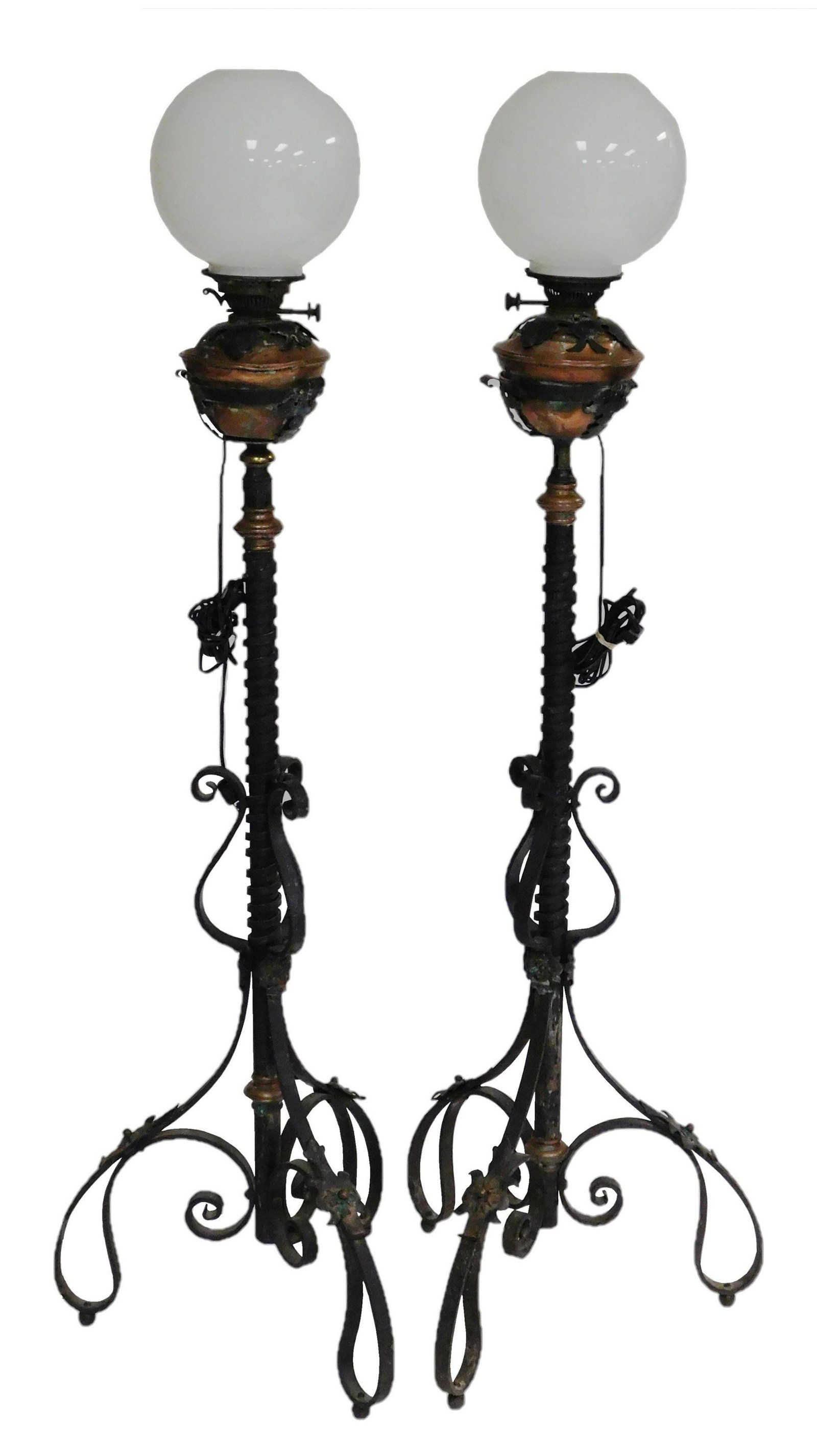 Two French standing fluid lamps, 19th C., wrought iron,: Two French standing fluid lamps, 19th C., wrought iron, copper, etc., electrified, copper font held in place by leaf form supports, iron central column with applied spiral decoration, raised on three 