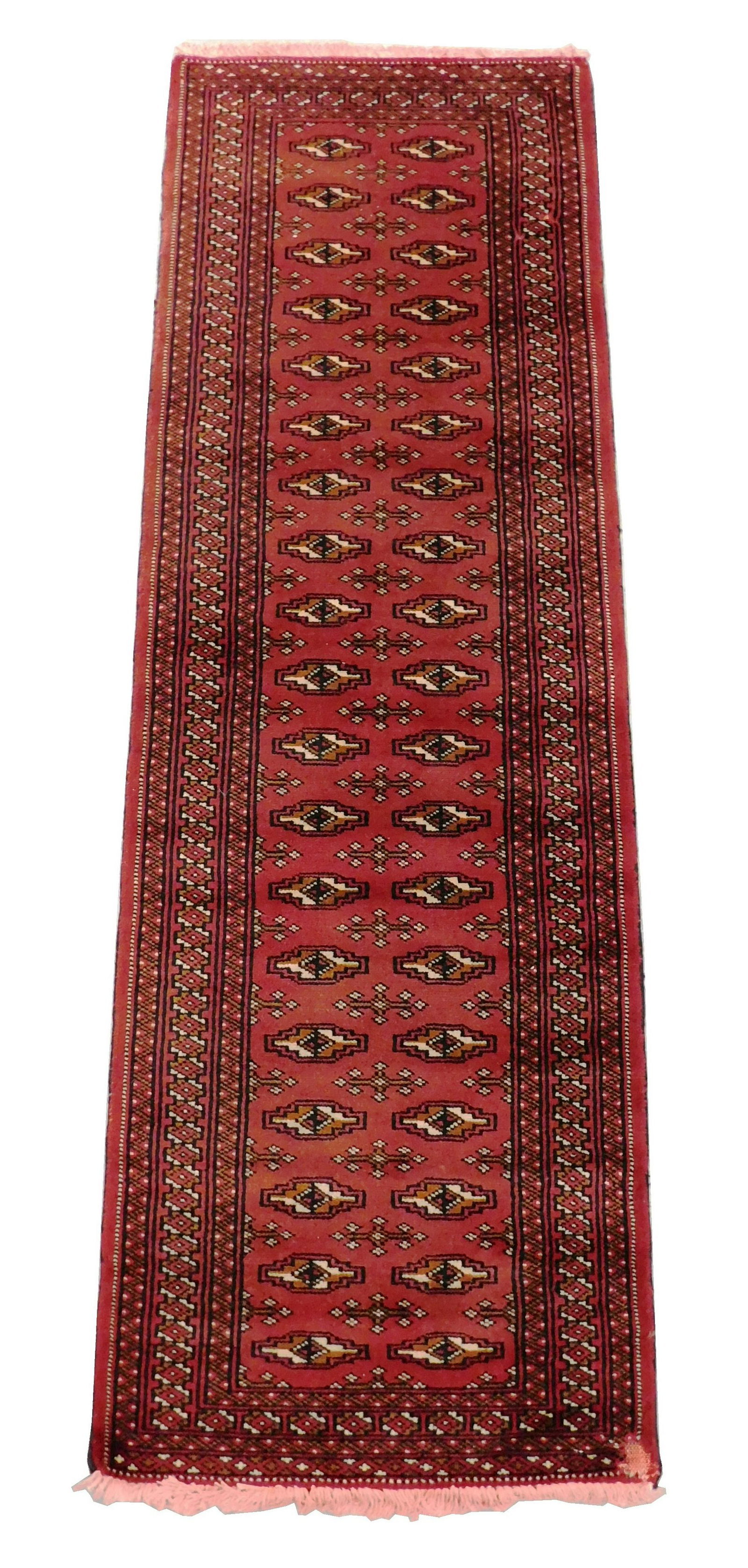 RUG: Pakistan Bokhara, 6' 4" x 2', 100% wool on cotton,: RUG: Pakistan Bokhara, 6' 4" x 2', 100% wool on cotton, two rows of repeating small medallions, color run on fringe and moth damage to corner.
