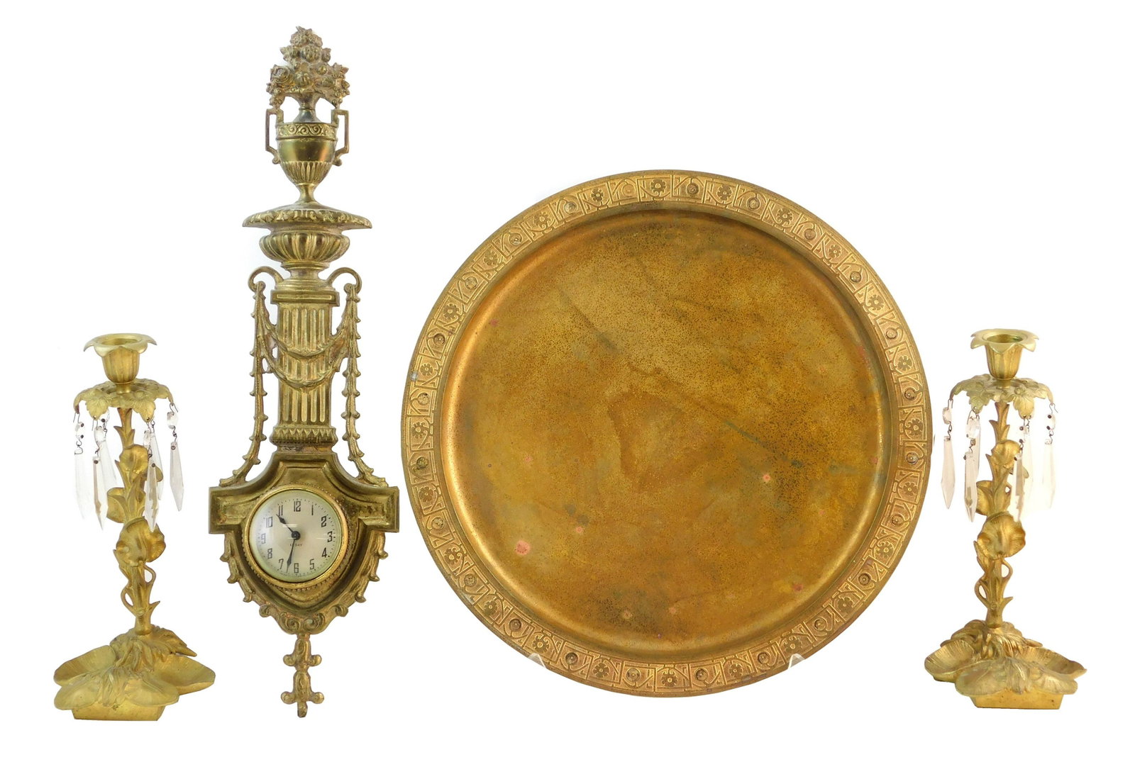 Four gilt pieces, including: Tiffany Furnaces metal: Four gilt pieces, including: Tiffany Furnaces metal plate with flower and vine pattern, likely missing abalone or enamel details on rim, 14" diam.; along with pair of Nouveau style lily design candles