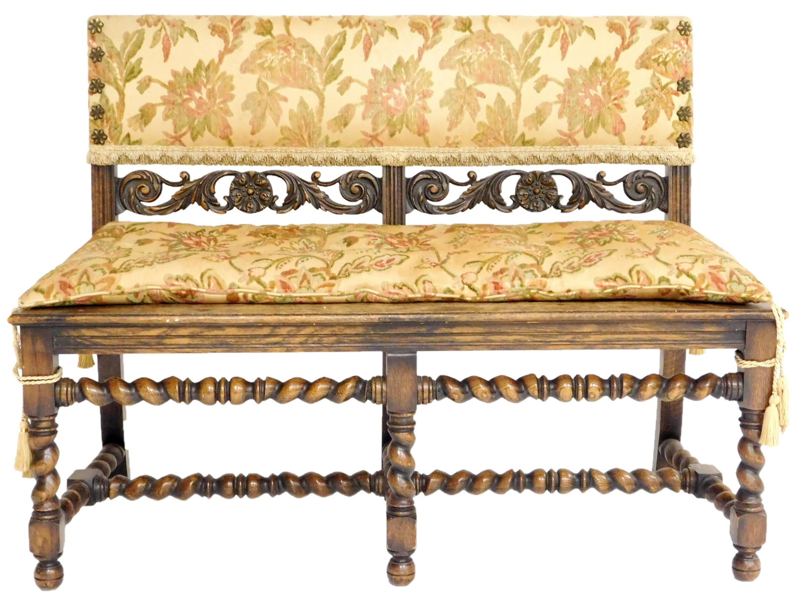Renaissance style bench with upholstered back rest in: Renaissance style bench with upholstered back rest in tan floral pattern over carved and pierced scroll splat, oversized flower form brass brads at sides, plank seat with removable cushion of same fab