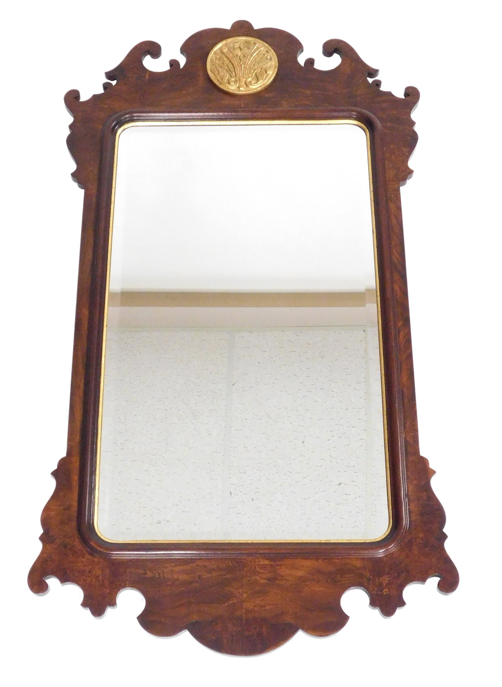 Wall mirror, Chippendale style, mahogany, gilded rondel: Wall mirror, Chippendale style, mahogany, gilded rondel in crest with raised decoration, oblong mirror with gilded minor border, wear consistent with age and use, 4' 6" h. x 2' 5" w.