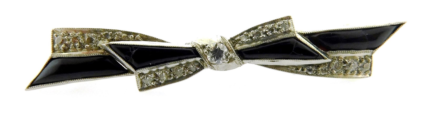 JEWELRY: Platinum diamond and onyx bow pin, tested platinum with 14K yellow gold pin stem, set with: JEWELRY: Platinum diamond and onyx bow pin, tested platinum with 14K yellow gold pin stem, set with nineteen round old European cut diamonds, approximate total weight: 0.25 ct, also set with four cali