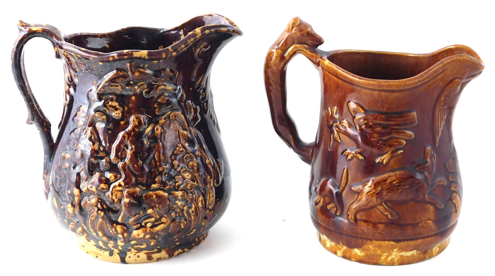 Two pottery milk jugs: one Rockingham mottled glaze with raised figural and foliate motif to both (1 of 5)