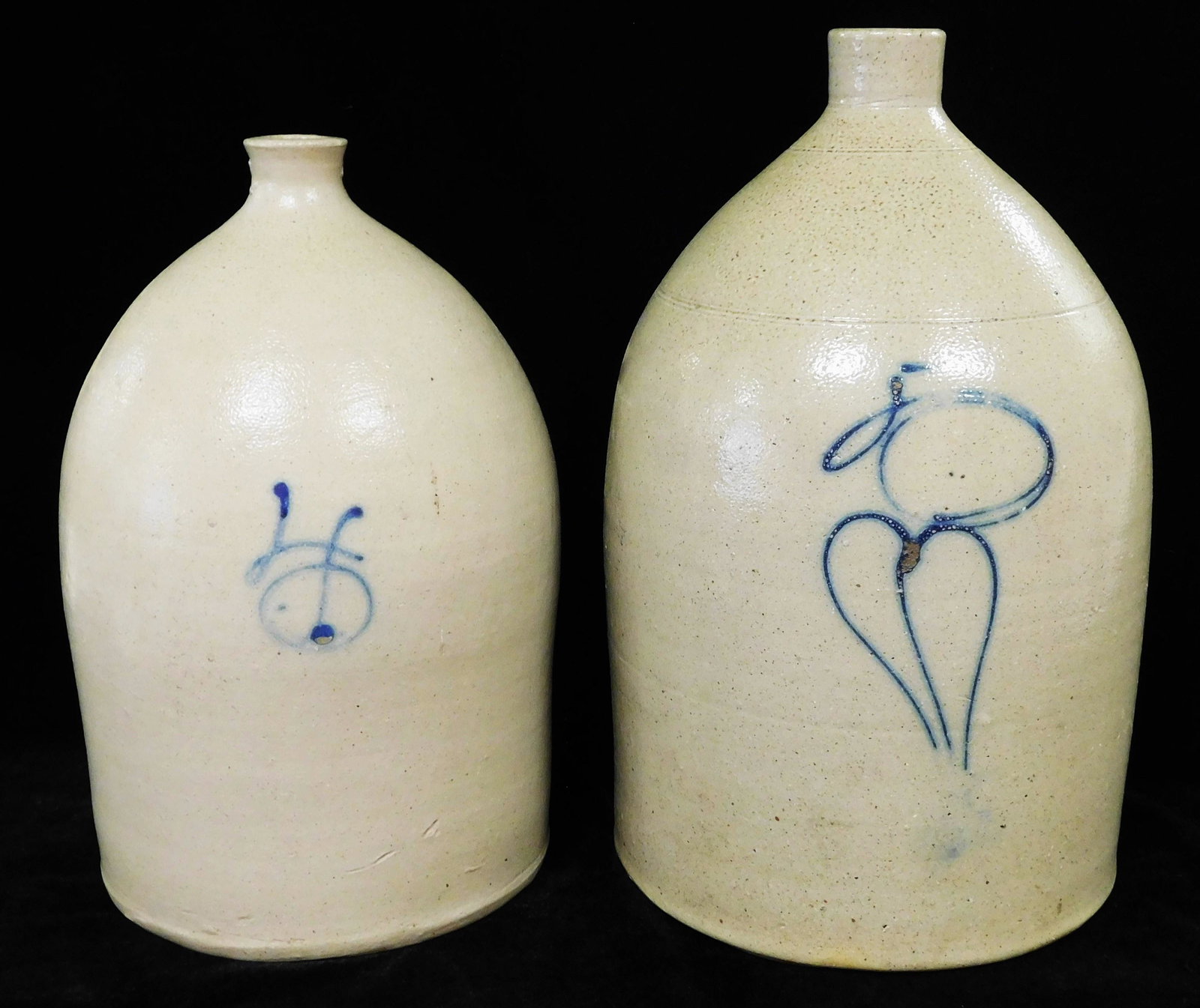 Two salt glazed stoneware jugs, four gallon and five gallon, each with applied handle and rounded (1 of 3)