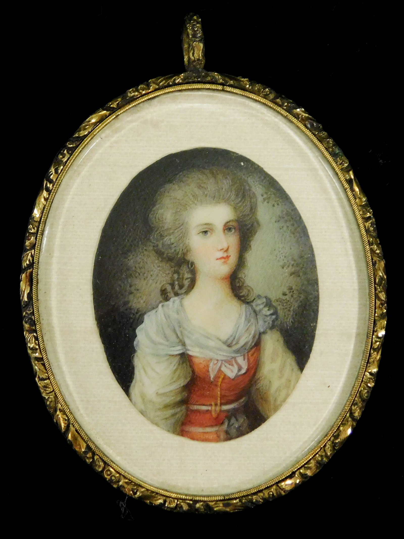 MINIATURE: Woman, oval support, powdered hair, red gown with white sleeves and fichu, support: MINIATURE: Woman, oval support, powdered hair, red gown with white sleeves and fichu, support displayed on white mat in metal locket frame with bail, lock of hair in disarray in reveal verso, ss: 2" x