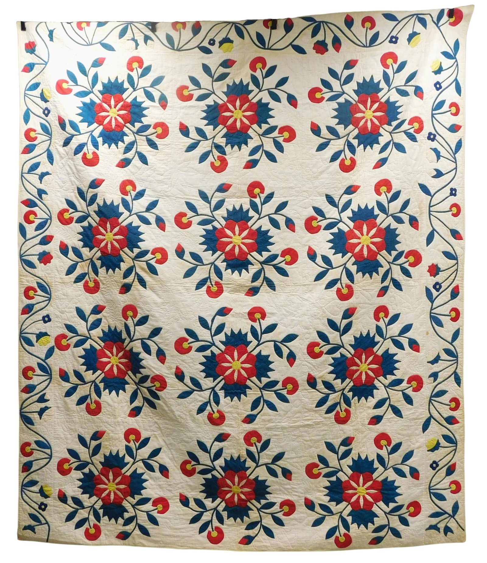 TEXTILE: Red, blue (originally green), and yellow on white applique quilt in swirling floral block (1 of 4)