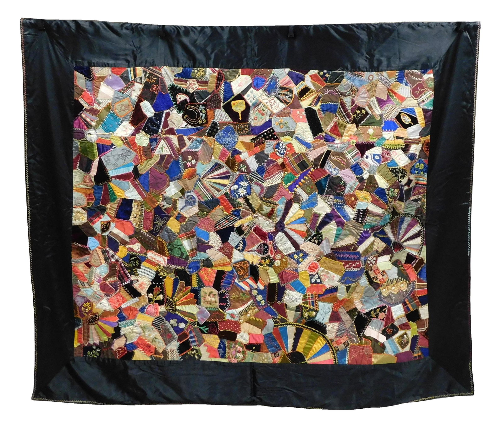 TEXTILE: Crazy quilt with black border embroidery and painting, feather, wear consistent with age: TEXTILE: Crazy quilt with black border embroidery and painting, feather, wear consistent with age and use including some minor damage, 60" x 71".