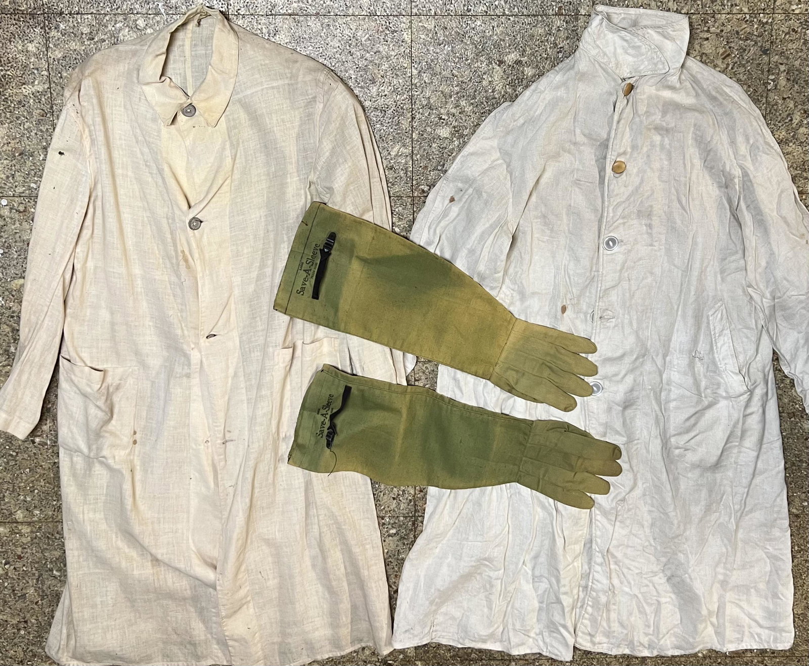 Two early dusters and a pair of ”Save-A-Sleeve” gloves - this was protective clothing to wear over: Two early dusters and a pair of ”Save-A-Sleeve” gloves - this was protective clothing to wear over dress garments in the early 1900’s brass era, good display condition.