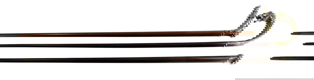 Three walking sticks, each with unique handles/finials, including: crook cane, with sterling lion: Three walking sticks, each with unique handles/finials, including: crook cane, with sterling lion head shaped handle, glass eyes, hallmarks near collar, 35" l.; horse head cane, 800 silver handle, hal