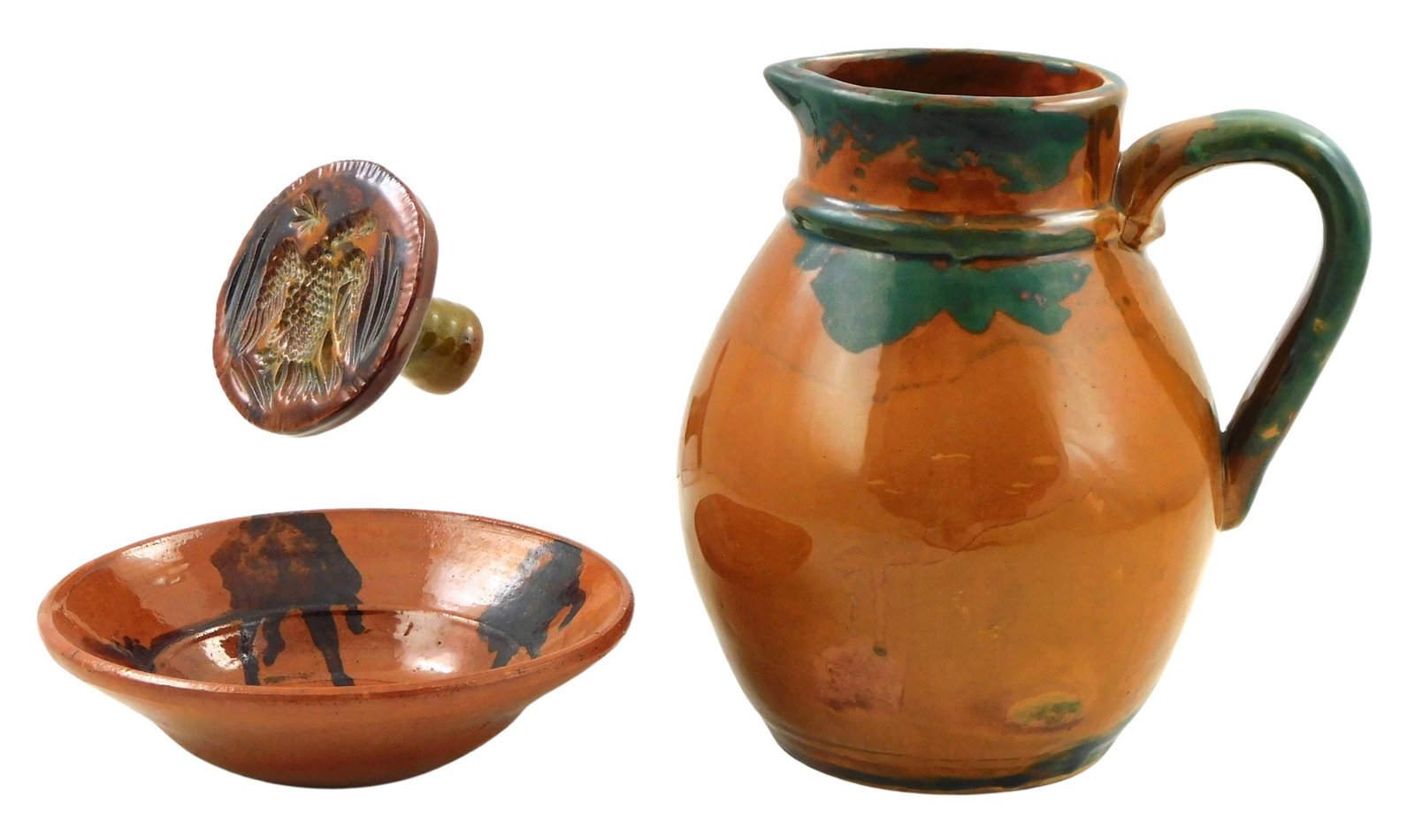 Three glazed redware pieces, including: pitcher with free form green decoration, scattered: Three glazed redware pieces, including: pitcher with free form green decoration, scattered craquelure, 8" h.; shallow dish with with manganese decoration to interior rim, scattered craquelure; and a c