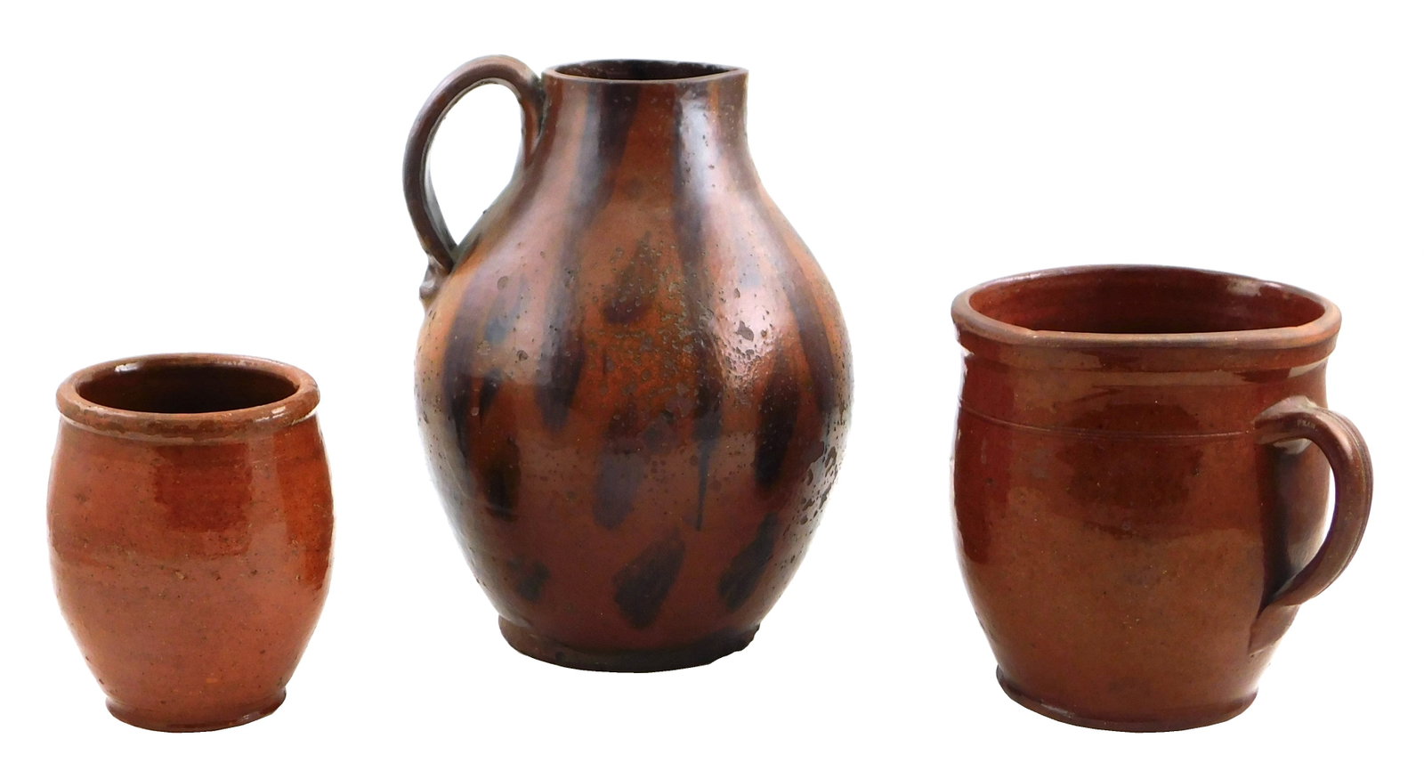 Three 19th C. glazed redware vessels, consisting of a pitcher and two crock, all with manganese: Three 19th C. glazed redware vessels, consisting of a pitcher and two crock, all with manganese decoration, details include: large pitcher with handle, manganese splotch decoration throughout, chippin