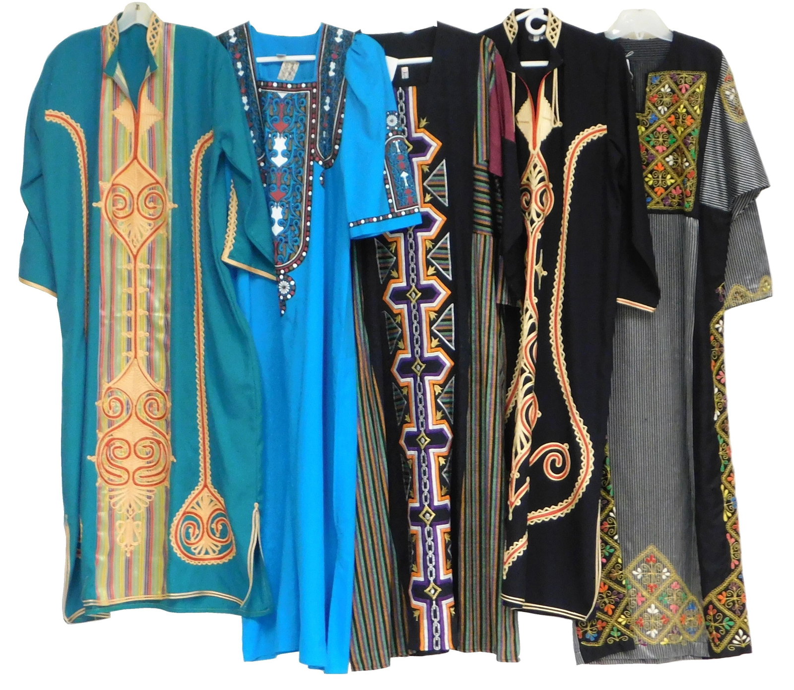 TEXTILES: Five caftans, late 20th C., the first turquoise dress with wide ribbon detail to front: TEXTILES: Five caftans, late 20th C., the first turquoise dress with wide ribbon detail to front with tan and red embroidery, flat lay measurements: armpit to armpit: 24 1/2” w., armpit to sleev