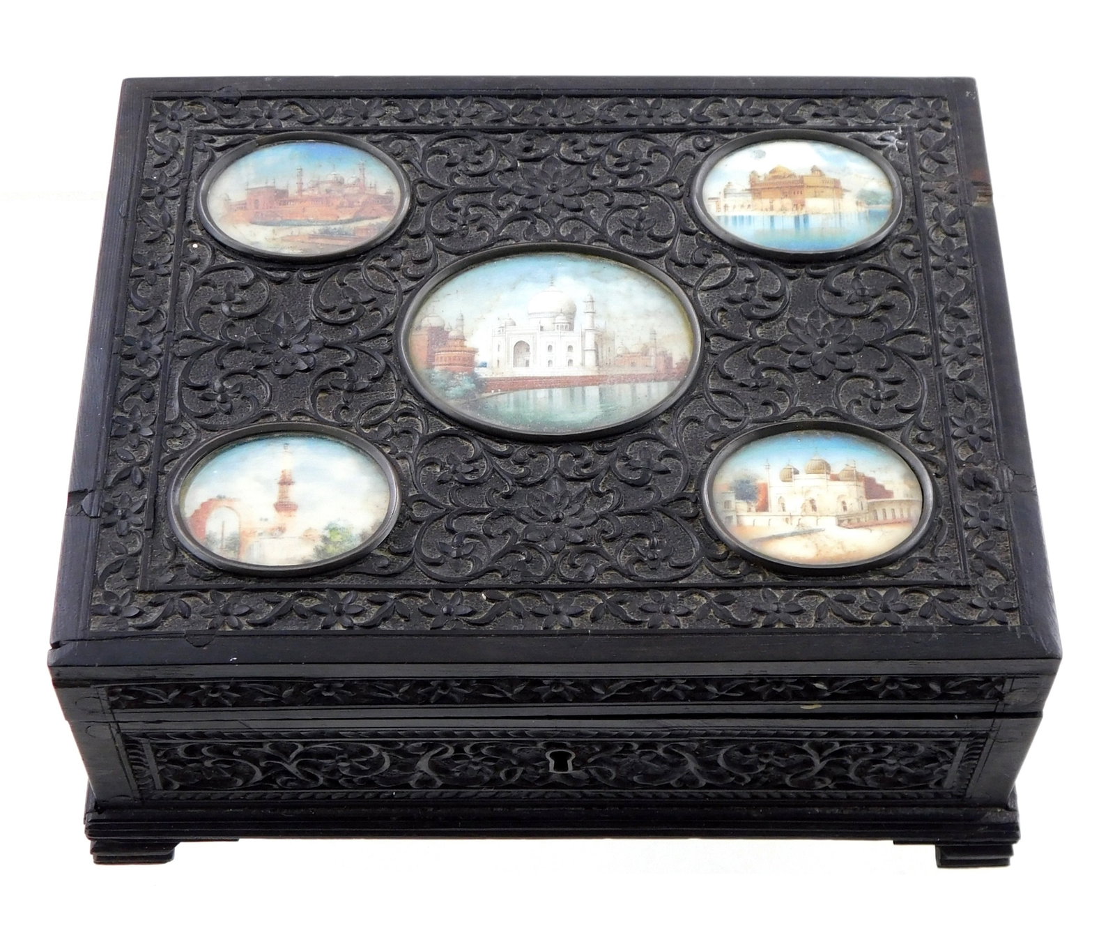 MINIATURES: Five miniature architectural portraits set into decorative wooden box, black finish,: MINIATURES: Five miniature architectural portraits set into decorative wooden box, black finish, hinged, scenes on oval supports including Taj Mahal, Red Fort, Qutub Minar etc., wear consistent with a