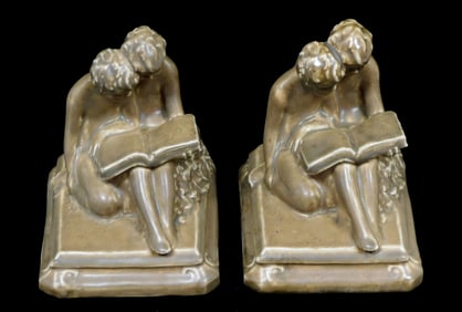 Rookwood Pottery pair of bookends, 1919, each figural form of two children seated together reading a