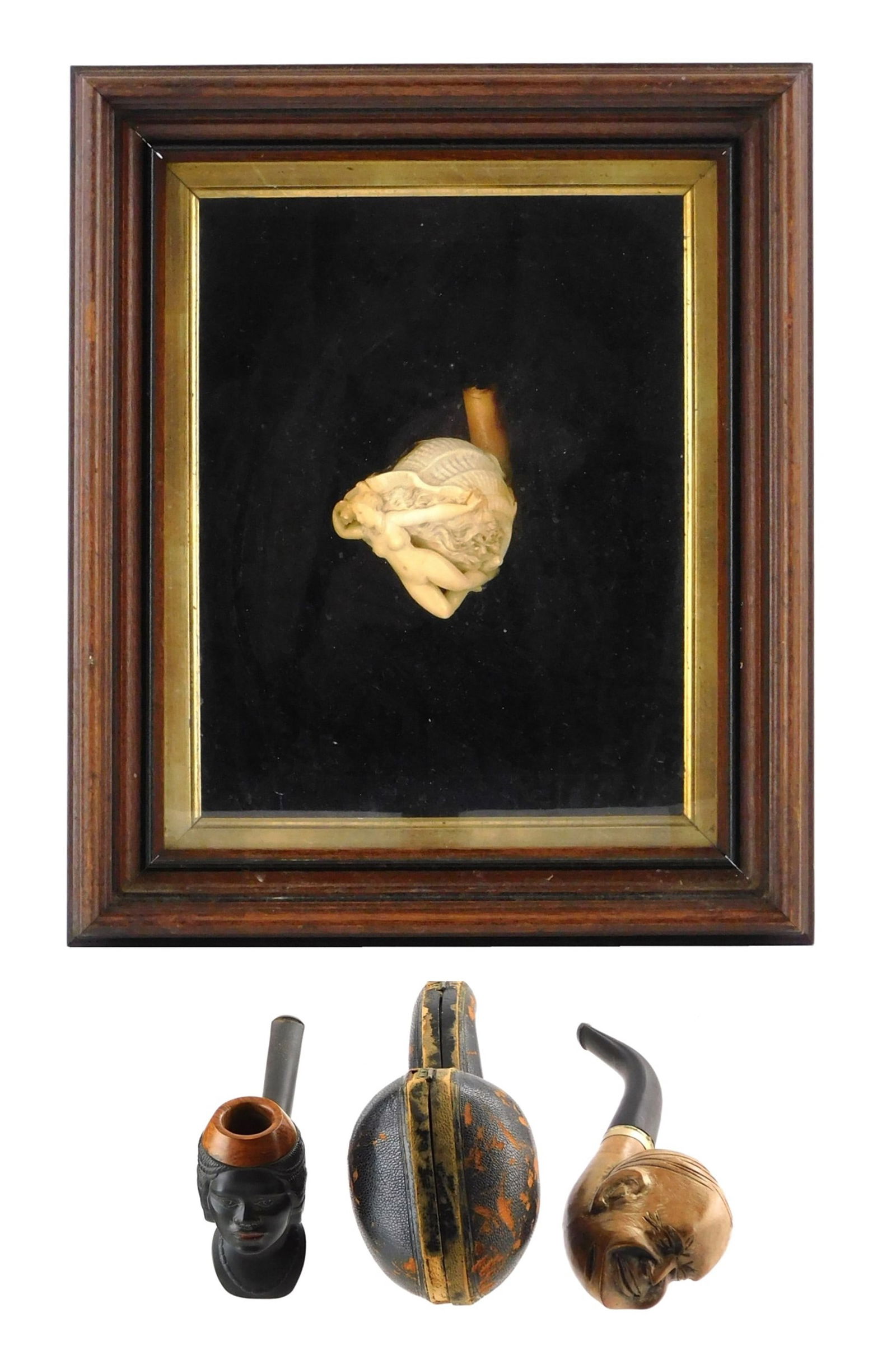 Three carved pipe bowls and one case, includes: Meerschaum pipe mounted in shadow box, depicts nude: Three carved pipe bowls and one case, includes: Meerschaum pipe mounted in shadow box, depicts nude woman with flowing hair emerging from a large clam shell, wear consistent with age and use, pipe siz
