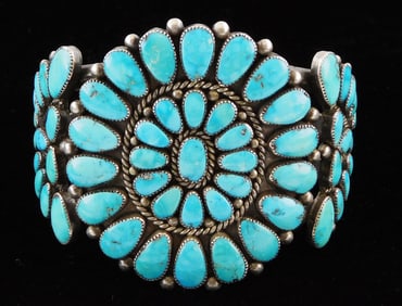 JEWELRY: Large Zuni cuff by Alice Quam with flower form center design and demilune sides, signed