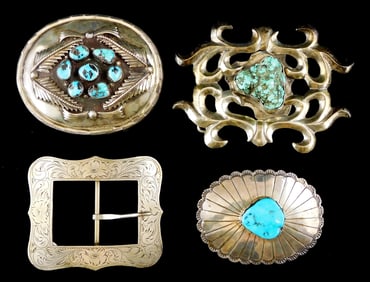 SILVER: Four silver southwest style belt buckles, the first with scrolling pattern surrounding an