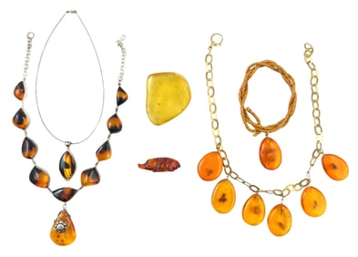 JEWELRY: Four Amber or amber type necklaces, along with an amber slab containing ants and a carved